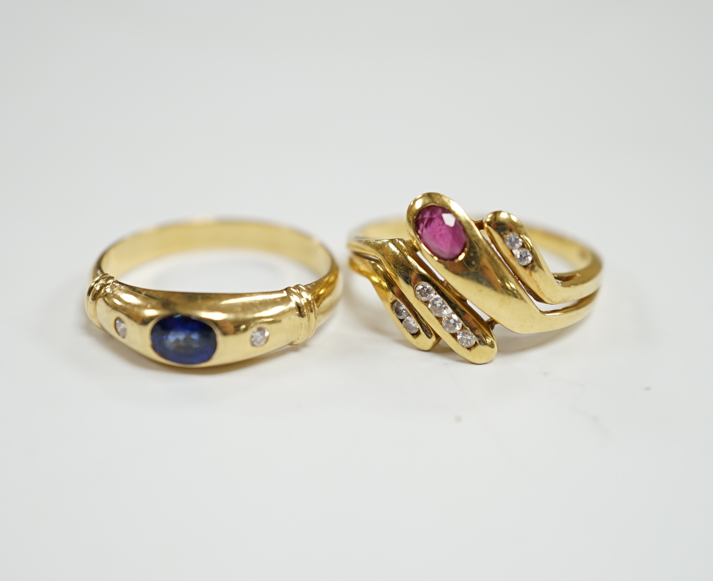 A modern 750 yellow metal and gypsy set single stone sapphire and two stone diamond set ring, size N, together with an Italian 750 yellow metal, ruby and diamond cluster set dress ring, size , gross weight 6.8 grams.